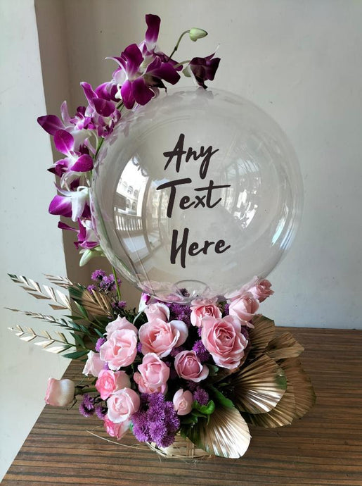 Bobo Balloons : Print Any text and customise clear balloon with orchid trailing on the balloon perched on top of pink roses with Gold colour leaves
