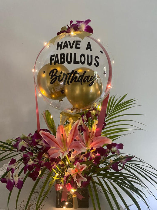 Orchids Balloon Bouquet - Print Any text and customise clear birthday balloon with orchid trailing on the balloon perched on top of yellow roses with Gold colour leaves